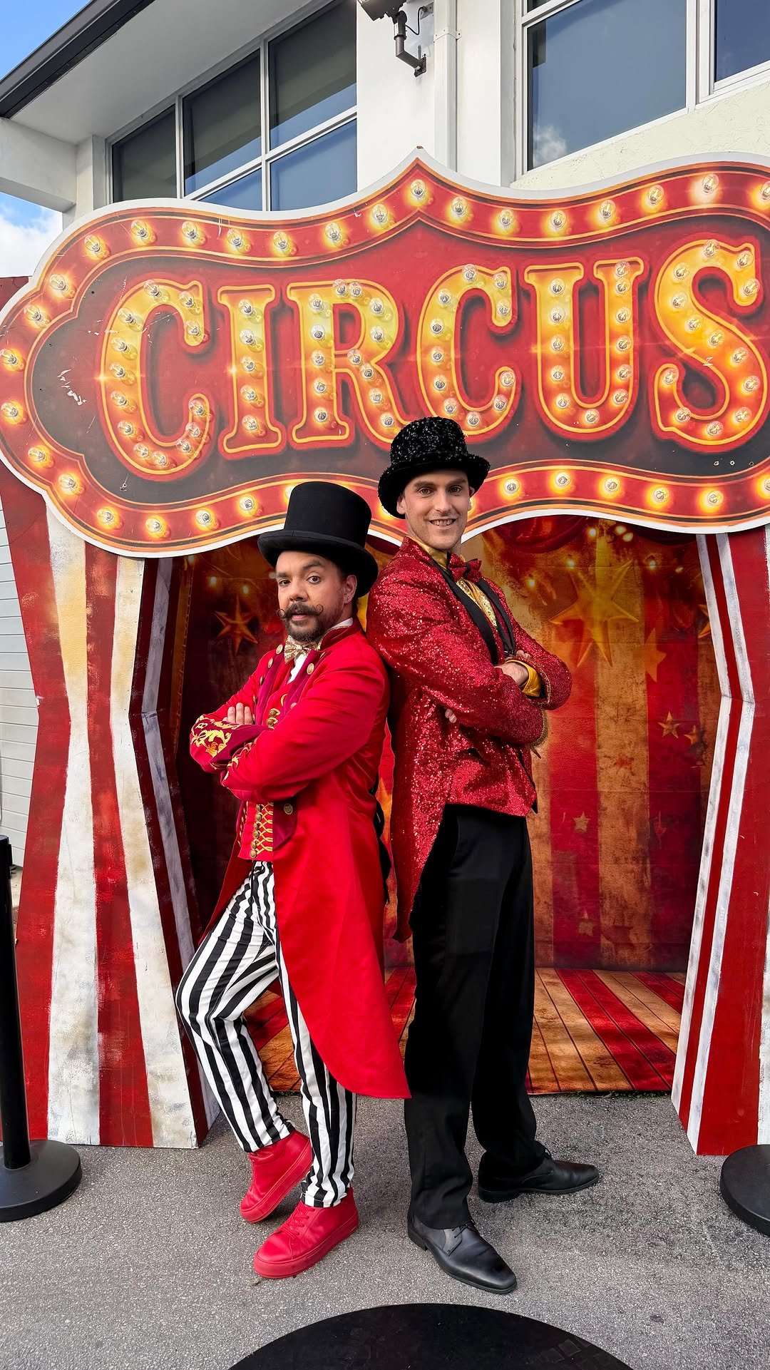 Anfitriones en traje de maestro de ceremonias rojo y negro para evento tipo circo.