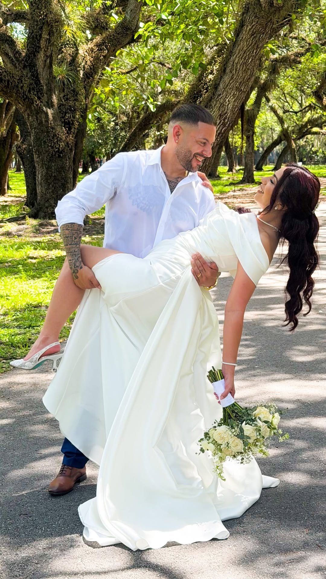 Novio cargando a la novia en brazos junto a un altar de cristal.